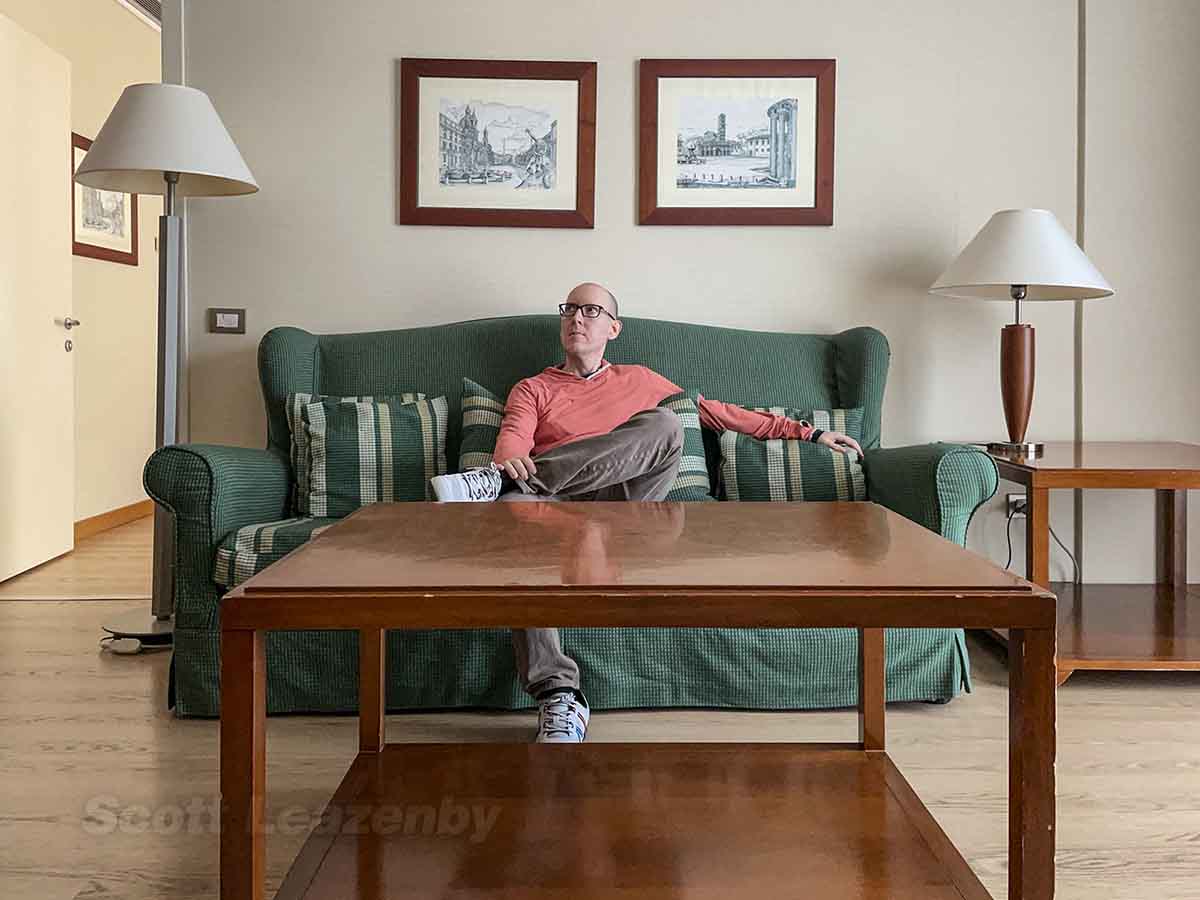 Scott sitting on the couch in a Hilton FCO suite 