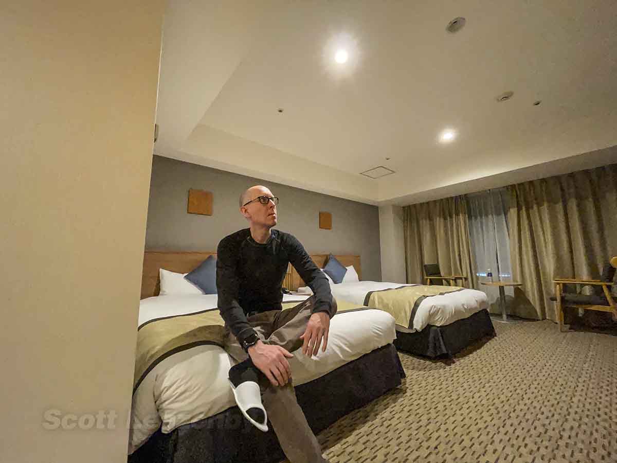 Scott sitting on the bed at the Tobu Hotel Narita 