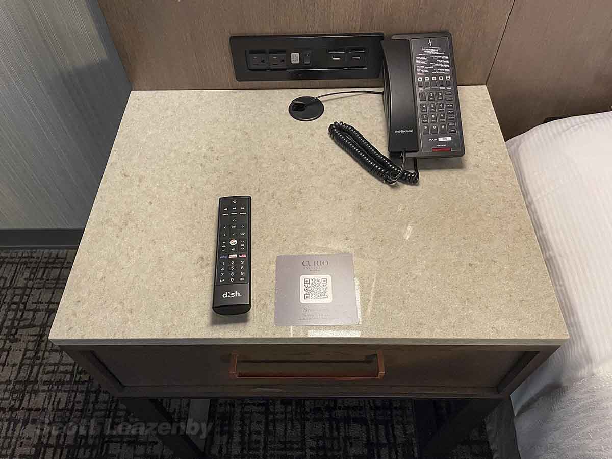 Bedside table with a phone and remote control