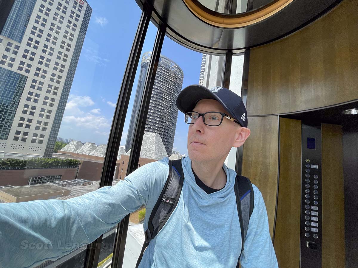 Scott riding in the elevator in the pan Pacific Hotel Singapore